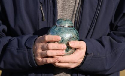 Eric Pranger holds an Urn that contains the ashes of Allen Livingston, Saturday, Dec. 21, 2024, in Westfield, Ind. (AP Photo/Darron Cummings)