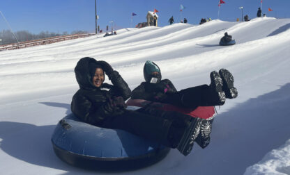 Nawal Hirsi, right, goes snow tubing with her family as part of a group promoting outdoors activities by Muslim women, at Elm Creek Park Reserve in Maple Grove, Minn., on Jan. 4, 2025. (AP Photo/Giovanna Dell'Orto)