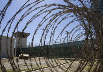 FILE - In this April 17, 2019, photo, reviewed by U.S. military officials, the control tower is seen through the razor wire inside the Camp VI detention facility in Guantanamo Bay Naval Base, Cuba. (AP Photo/Alex Brandon, File)