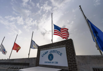 FILE - In this photo reviewed by U.S. military officials, flags fly at half-staff at Camp Justice, Aug. 29, 2021, in Guantanamo Bay Naval Base, Cuba. (AP Photo/Alex Brandon, File)