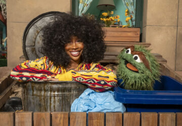 This image released by Sesame Workshop shows singer SZA, left, with muppet character Oscar the Grouch on the set of 