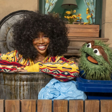 This image released by Sesame Workshop shows singer SZA, left, with muppet character Oscar the Grouch on the set of 