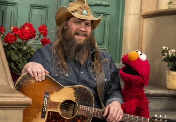 This image released by Sesame Workshop shows singer-songwriter Chris Stapleton, left, with muppet character Elmo on the set of 