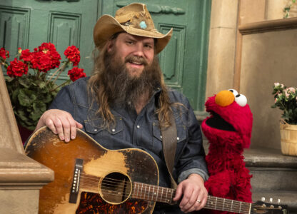 This image released by Sesame Workshop shows singer-songwriter Chris Stapleton, left, with muppet character Elmo on the set of 