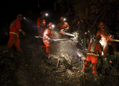 A California Department of Corrections hand crew works containment lines ahead of the Palisades Fire Tuesday, Jan. 14, 2025 in Santa Monica, Calif. (AP Photo/Ethan Swope)