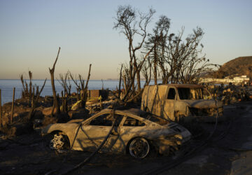 Charred vehicles sit along the Pacific Coast Highway, Tuesday, Jan. 14, 2025, in Malibu, Calif. (AP Photo/Carolyn Kaster)