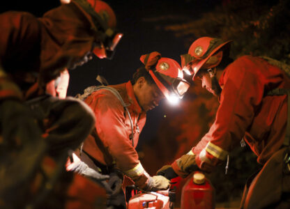 A California Department of Corrections hand crew works containment lines ahead of the Palisades Fire Tuesday, Jan. 14, 2025 in Santa Monica, Calif. (AP Photo/Ethan Swope)