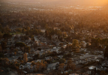 Trucks drive through a neighborhood destroyed by the Eaton Fire, Tuesday, Jan. 14, 2025, in Altadena, Calif. (AP Photo/John Locher)