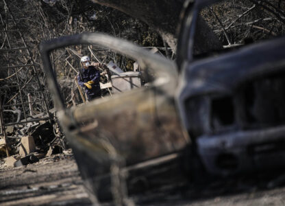 A search and rescue worker sifts through the wreckage of a home destroyed by the Eaton Fire, Tuesday, Jan. 14, 2025, in Altadena, Calif. (AP Photo/John Locher)