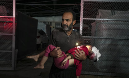 A Palestinian man carries a wounded girl, following an Israeli bombardment on the Gaza Strip, as they arrive at the Al-Aqsa Martyrs hospital in Deir al-Balah, Tuesday, Jan. 14, 2025. (AP Photo/Abdel Kareem Hana)