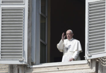 FILE - Pope Francis delivers his blessing from the window of his private library overlooking St. Peter's Square, at the Vatican, March 22, 2020. (AP Photo/Andrew Medichini, File)