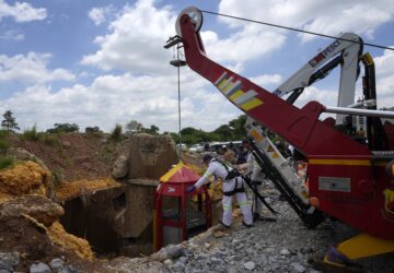 Mine rescue workers host up a cage that was used to rescue trapped miners at an abandoned gold mine, where miners were rescued from below ground, in Stilfontein, South Africa, Thursday, Jan. 16, 2025. (AP Photo/Themba Hadebe)