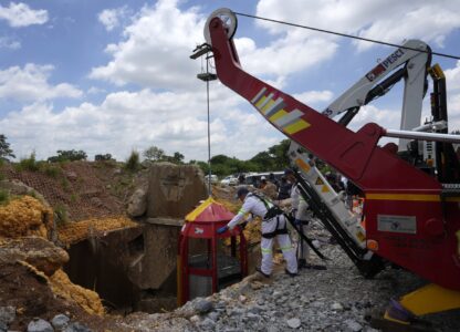 Mine rescue workers host up a cage that was used to rescue trapped miners at an abandoned gold mine, where miners were rescued from below ground, in Stilfontein, South Africa, Thursday, Jan. 16, 2025. (AP Photo/Themba Hadebe)