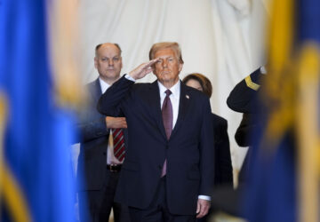 President Donald Trump salutes while on stage in Emancipation Hall at the 60th Presidential Inauguration, Monday, Jan. 20, 2025, at the U.S. Capitol in Washington. (Al Drago/Pool Photo via AP)