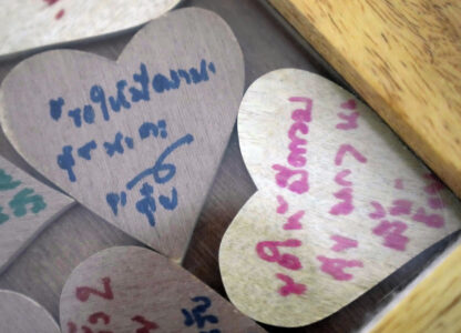 Pieces of heart-shaped wood with messages from friends of Sunma Piamboon and Danaya Phonphayung are kept in a wooden frame in Bangkok, Thailand, on Jan. 13, 2025. The words read 