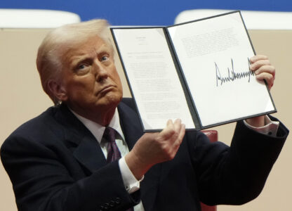 President Donald Trump holds up an executive order after signing it at an indoor Presidential Inauguration parade event in Washington, Monday, Jan. 20, 2025. (AP Photo/Matt Rourke)