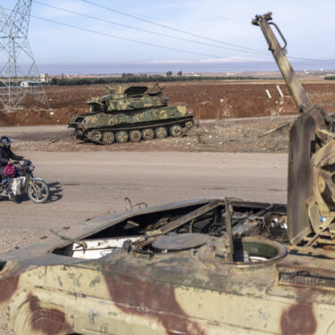 A family drives past tanks that belonged to the Assad government, in Nawa, near Daraa, Syria, Jan. 4, 2025. (AP Photo/Mosa'ab Elshamy)