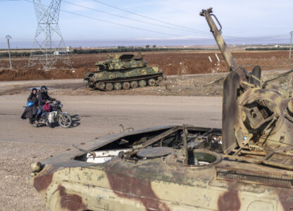 A family drives past tanks that belonged to the Assad government, in Nawa, near Daraa, Syria, Jan. 4, 2025. (AP Photo/Mosa'ab Elshamy)