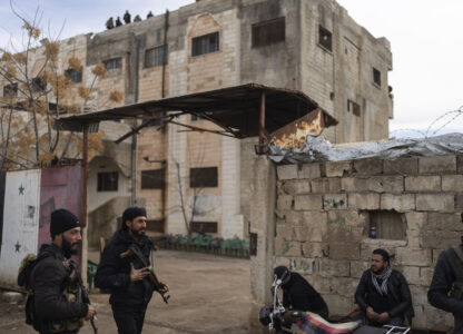 Members of the new Syrian security forces stand outside a security building, in Nawa, near Daraa, Syria, Jan. 4, 2025. (AP Photo/Mosa'ab Elshamy)