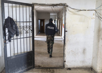 A member of the new Syrian security forces walks into a military headquarters that belonged to the Assad government, in Nawa, near Daraa, Syria, Jan. 4, 2025. (AP Photo/Mosa'ab Elshamy)