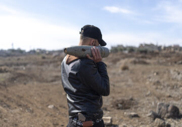 A member of the new Syrian security forces carries ammunition that belonged to the Assad government, in Nawa, near Daraa, Syria, Jan. 4, 2025. (AP Photo/Mosa'ab Elshamy)