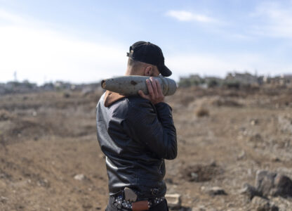 A member of the new Syrian security forces carries ammunition that belonged to the Assad government, in Nawa, near Daraa, Syria, Jan. 4, 2025. (AP Photo/Mosa'ab Elshamy)