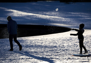 A child throws a snowball at his father in Hampton Park after a winter storm dropped ice and snow Wednesday, Jan. 22, 2025, in Charleston, S.C. (AP Photo/Mic Smith)