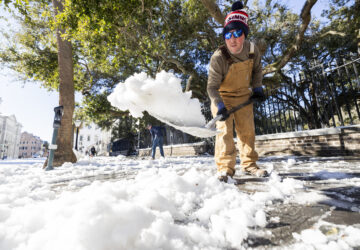 Dylan Gilbert, with the City of Charleston, removes snow in front of City Hall after a winter storm dropped ice and snow Wednesday, Jan. 22, 2025, on Charleston, S.C. (AP Photo/Mic Smith)