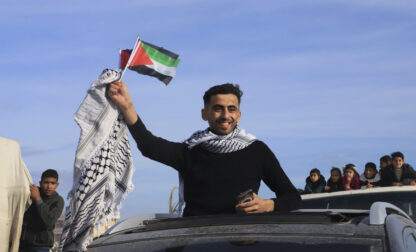 FILE - A man waves a Palestinian flag as he returns home to Rafah, after a ceasefire deal between Israel and Hamas went into effect, in Rafah, Gaza Strip, Jan. 19, 2025. (AP Photo/Mariam Dagga, File)