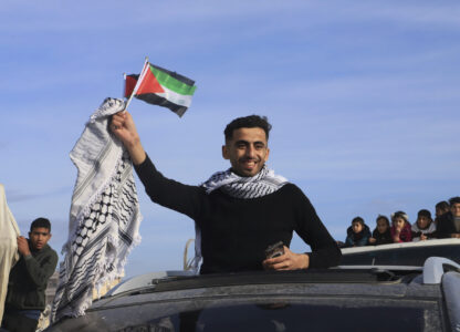 FILE - A man waves a Palestinian flag as he returns home to Rafah, after a ceasefire deal between Israel and Hamas went into effect, in Rafah, Gaza Strip, Jan. 19, 2025. (AP Photo/Mariam Dagga, File)