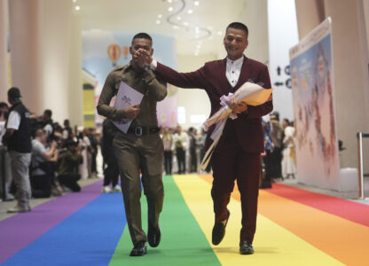 A just-married couple from the LGBTQ+ community walks on rainbow carpet in Bangkok, Thailand, Thursday, Jan. 23, 2025, on the first day a law took effect granting them the same rights as heterosexual couples. (AP Photo/Sakchai Lalit)