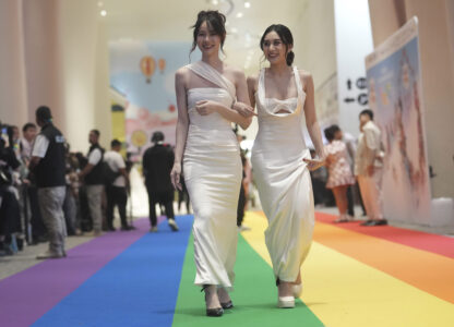 A just-married couple from the LGBTQ+ community walks on rainbow carpet in Bangkok, Thailand, Thursday, Jan. 23, 2025, on the first day a law took effect granting them the same rights as heterosexual couples. (AP Photo/Sakchai Lalit)