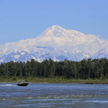 FILE - A boat is seen on the Susitna River near Talkeetna, Alaska, on Sunday, June 13, 2021, with Denali in the background. Denali, the tallest mountain on the North American continent, is located about 60 miles northwest of Talkeetna. (AP Photo/Mark Thiessen, File)