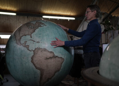 FILE - Peter Bellerby, the founder of Bellerby & Co. Globemakers, holds a globe at a studio in London, Tuesday, Feb. 27, 2024. (AP Photo/Kin Cheung, File)