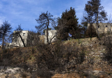 An Israeli flag seen among burnt trees and heavy damage from the 14-month war between Hezbollah and Israel in Kibbutz Manara, on the border with Lebanon, northern Israel, Jan. 5, 2025. (AP Photo/Ariel Schalit)