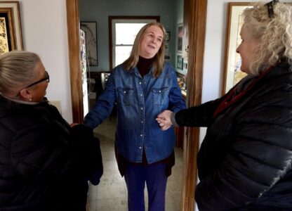 Barbara Teed thanks Jan Orcutt and Wendy Vossen for delivering food for herself and her adult son Ryan, who has Down syndrome, on Wednesday, Jan. 29, 2025, in Bloomington, Minn. (AP photo/Mark Vancleave)