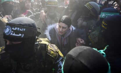 Israeli captive Arbel Yehoud, 29, who has been held hostage by Hamas in Gaza since October 7, 2023, is escorted by Hamas and Islamic Jihad fighters as she is handed over to the Red Cross in Khan Younis, southern Gaza Strip, Thursday Jan. 30, 2025.(AP Photo/Abdel Kareem Hana)