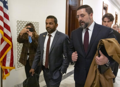 FILE - Kash Patel, President-elect Donald Trump's pick to be the director of the FBI, center, walks between meetings on Capitol Hill, Monday, Dec. 9, 2024, in Washington. (AP Photo/Mark Schiefelbein, File)