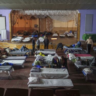 People sit on beds after evacuation from the frontline at a center for displaced people in Pavlohrad, Ukraine, Saturday, Feb. 1, 2024. (AP Photo/Evgeniy Maloletka)Maloletka)