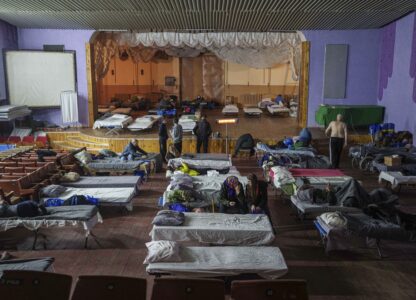 People sit on beds after evacuation from the frontline at a center for displaced people in Pavlohrad, Ukraine, Saturday, Feb. 1, 2024. (AP Photo/Evgeniy Maloletka)Maloletka)