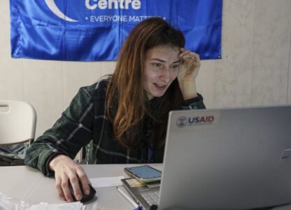 A social worker looks at a laptop with a USAID logo, at a center for displaced people in Pavlohrad, Ukraine, Saturday, Feb. 1, 2024. (AP Photo/Evgeniy Maloletka)