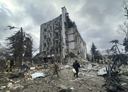 In this photo provided by the Ukrainian Emergency Services on Tuesday, Feb. 4, 2025, rescue workers walk in front of a building that was heavily damaged by a Russian strike in Izium, Ukraine. (Ukrainian Emergency Service via AP)