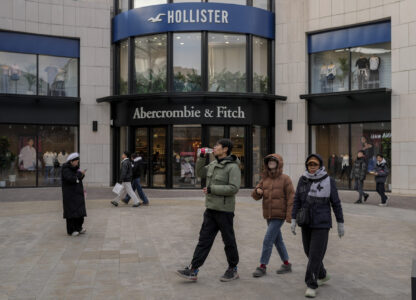 Chinese shoppers tour past American fashion boutiques at an outdoor shopping mall in Beijing, Tuesday, Feb. 4, 2025. (AP Photo/Andy Wong)