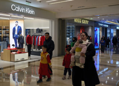 Shoppers tour by Calvin Klein and Tommy Hilfiger fashion boutiques, which are owned by PVH Group, at a shopping mall in Beijing, Tuesday, Feb. 4, 2025. (AP Photo/Andy Wong)