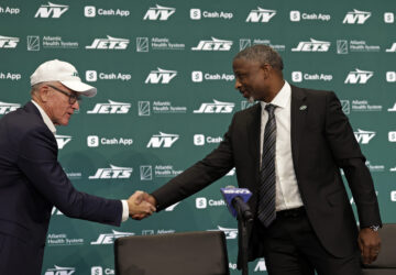 FILE - New York Jets new head coach Aaron Glenn, right, shakes hands with team owner Woody Johnson, left, during a news conference at the NFL football team's training facility Jan. 27, 2025, in Florham Park, N.J. (AP Photo/Adam Hunger,File)