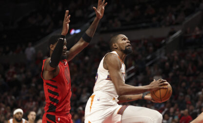 Phoenix Suns forward Kevin Durant, right, drives to the basket past Portland Trail Blazers center Deandre Ayton during overtime of an NBA basketball game Monday, Feb. 3, 2025, in Portland, Ore. (AP Photo/Amanda Loman)