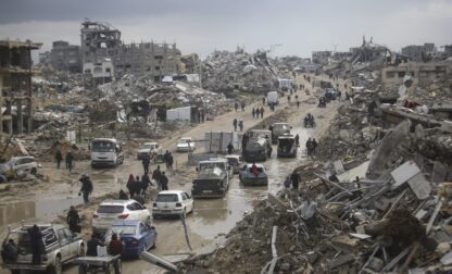 FILE - Cars and pedestrians move along a road amid widespread destruction caused by the Israeli military's ground and air offensive against Hamas in Gaza City's Jabaliya refugee camp, Friday, Feb. 7, 2025. (AP Photo/Jehad Alshrafi, file)