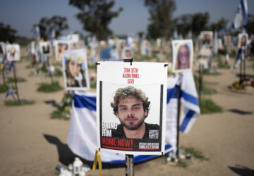 FILE - A poster depicting Israeli hostage Alon Ohel is displayed in Re'im, southern Israel at the Gaza border, Feb. 26, 2024, at a memorial site for the Nova music festival site where he was kidnapped to Gaza by Hamas on Oct. 7, 2023. (AP Photo/Maya Alleruzzo, File)