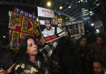 Einav Zangauker holds a poster of her son, Matan, who is held hostage by Hamas in the Gaza Strip, at a protest outside of Israel's Ministry of Defense in Tel Aviv, Israel, Monday, Feb. 10, 2025, after the militant group announced it would delay hostage releases in the Gaza Strip after accusing Israel of violating a fragile ceasefire. (AP Photo/Ohad Zwigenberg)