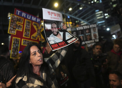 Einav Zangauker holds a poster of her son, Matan, who is held hostage by Hamas in the Gaza Strip, at a protest outside of Israel's Ministry of Defense in Tel Aviv, Israel, Monday, Feb. 10, 2025, after the militant group announced it would delay hostage releases in the Gaza Strip after accusing Israel of violating a fragile ceasefire. (AP Photo/Ohad Zwigenberg)